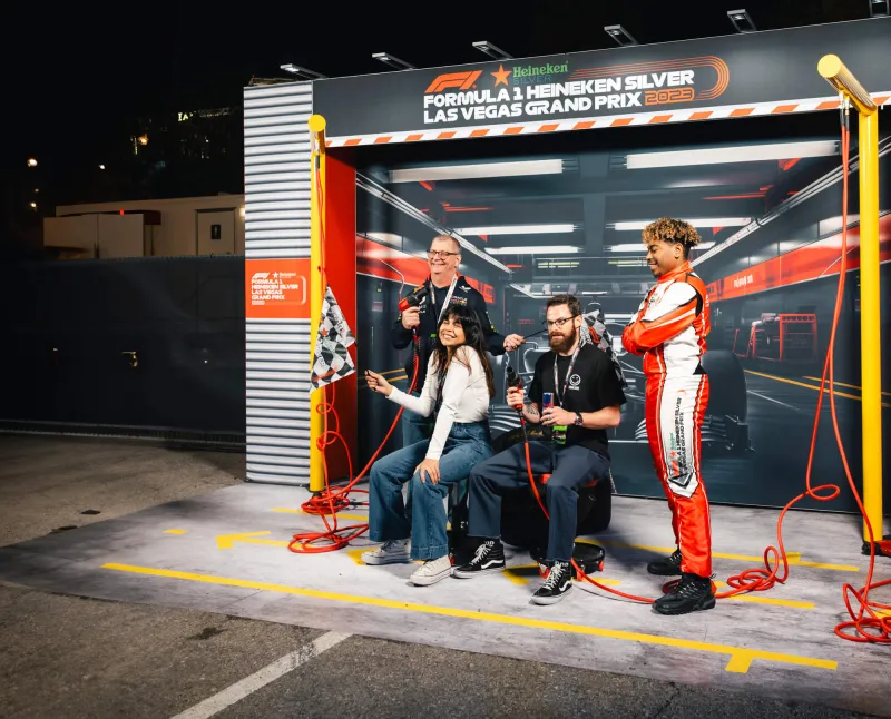 Heineken Silver Pit Stop fan activation at the F1 Las Vegas Grand Prix 2023. Branded pit-stop experience with Heineken-themed canopy and lighting.